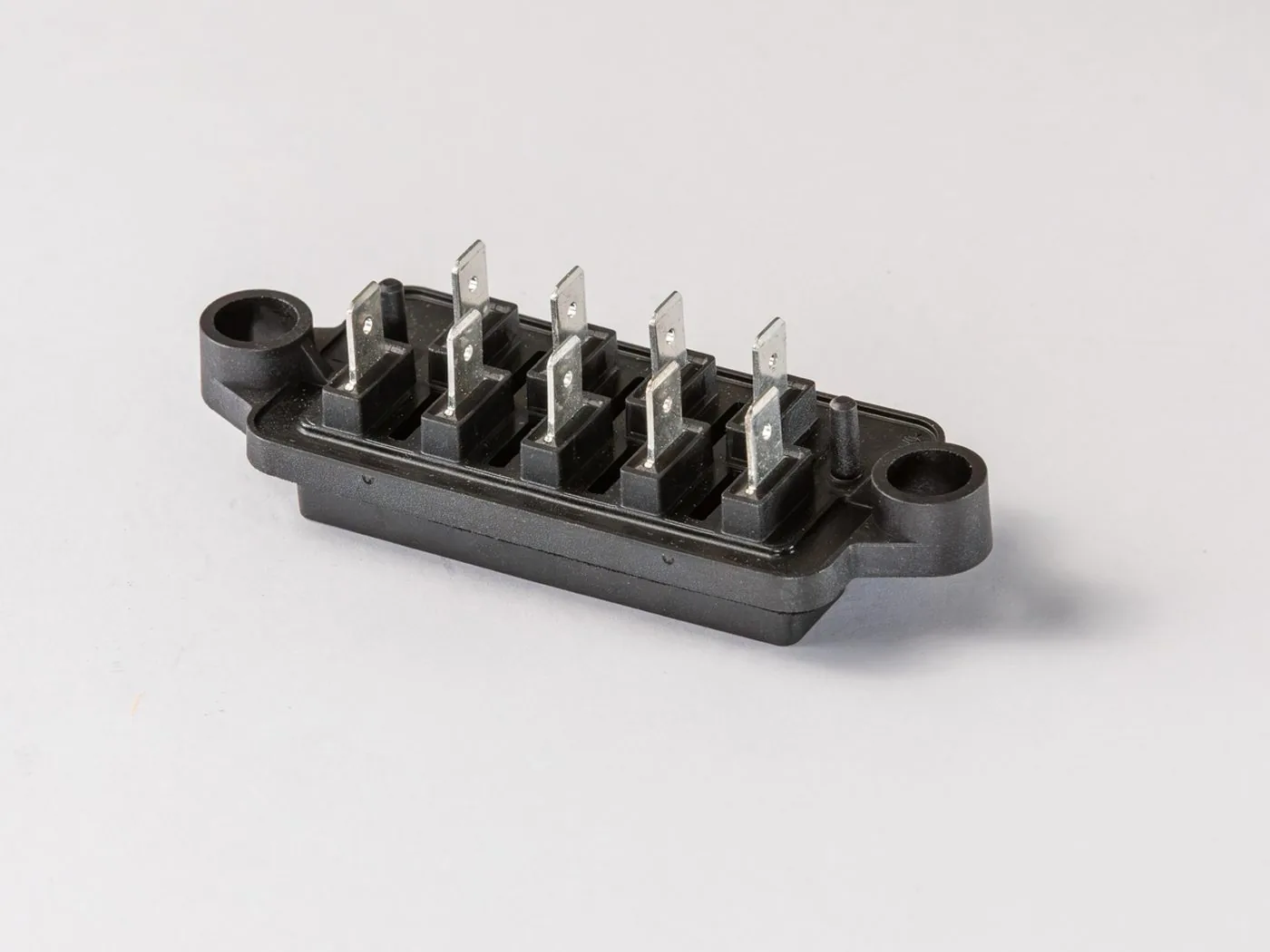 Anschlussblock aus schwarzem Kunststoff mit umspritzten Flachkontakten aus Metall